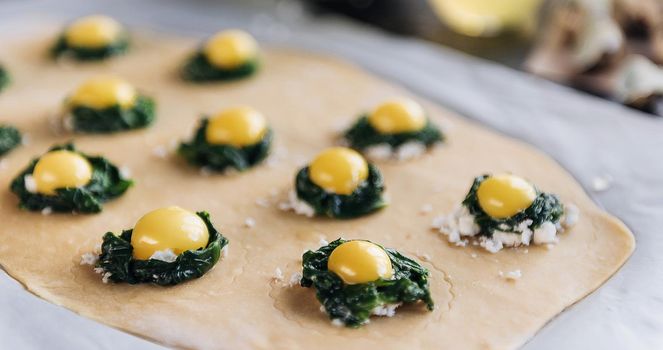 Step by step the chef prepares ravioli with ricotta cheese, yolks quail eggs and spinach with spices. The chef prepares the filling on the dough