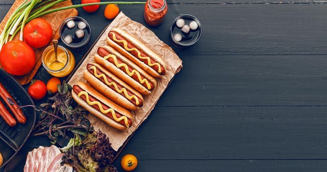 Barbecue Grilled Hot Dogs with  yellow American mustard, On a dark wooden background