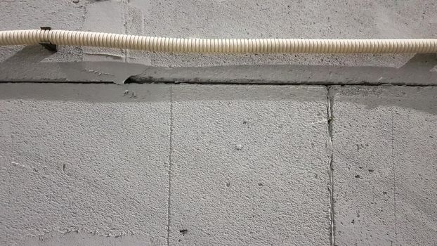 The electric cable is laid in a protective corrugation over the wall. electrical wires are carried on the wall for connecting sockets and switches