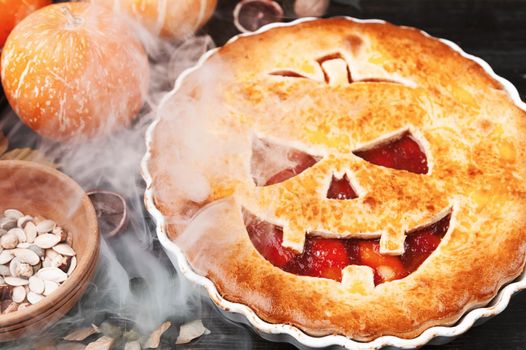 Delicious homemade pie for halloween with a filling of pumpkin-strawberry jam and peaches