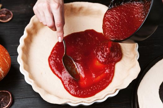 Chef cooks a pie for Halloween with a filling of pumpkin-strawberry jam and peaches