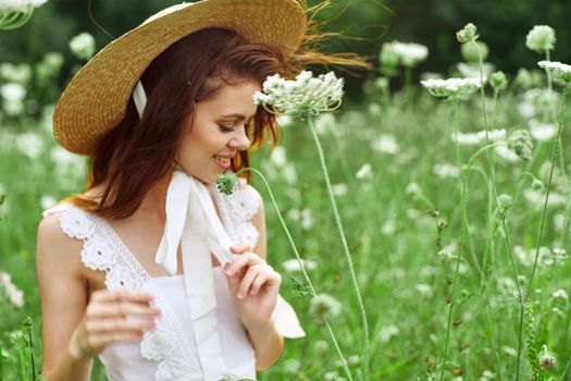 Woman in white dress and hat on nature flowers freedom. High quality photo