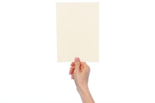 Female hand holding blank white sheet of paper isolated on white background