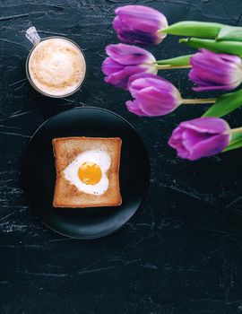 Still breakfast for a loved one with tulips on a dark background