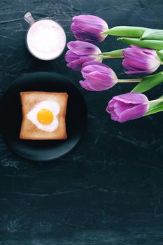Still breakfast for a loved one with tulips on a dark background