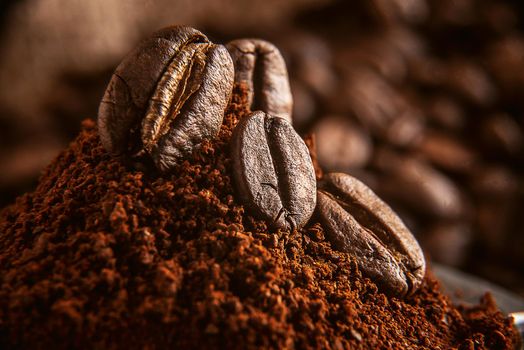 ground coffee poured into the holder on which the grains of roasted, fragrant coffee lie. on the background of fried grains