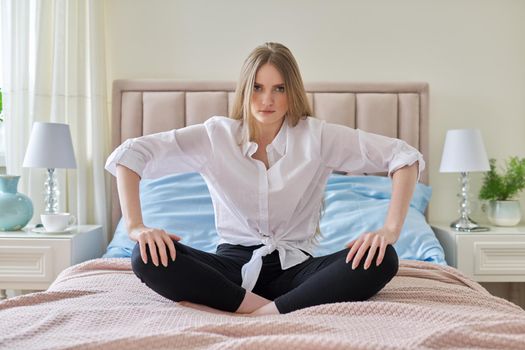 Serious anxious worried young woman sitting at home in bed. Problems, difficulties, psychological trauma, feeling, mental health, youth concept