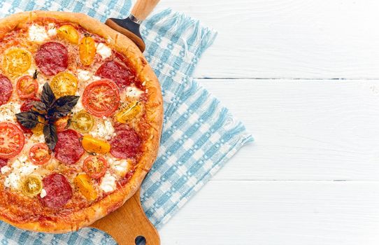 pepperoni italian pizza with salami and cheese on rustic wooden white background