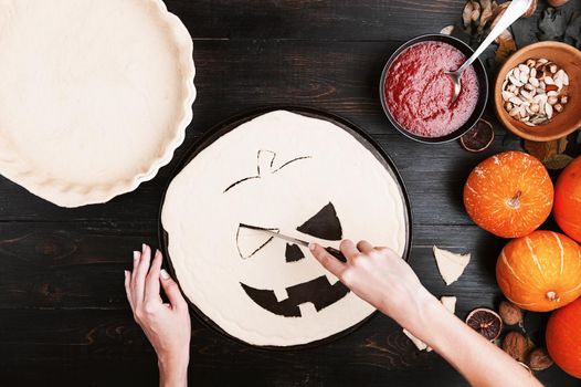 Chef cooks a pie for Halloween with a filling of pumpkin-strawberry jam and peaches