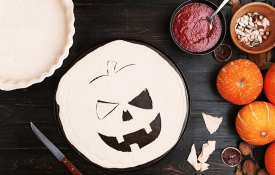 Chef cooks a pie for Halloween with a filling of pumpkin-strawberry jam and peaches