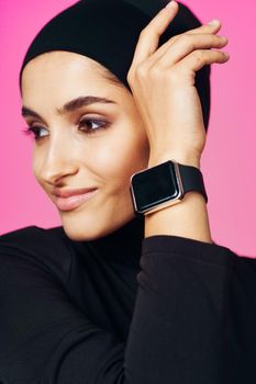 muslim woman with smart watch technology gadget pink background. High quality photo