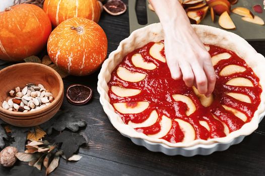 Chef cooks a pie for Halloween with a filling of pumpkin-strawberry jam and peaches