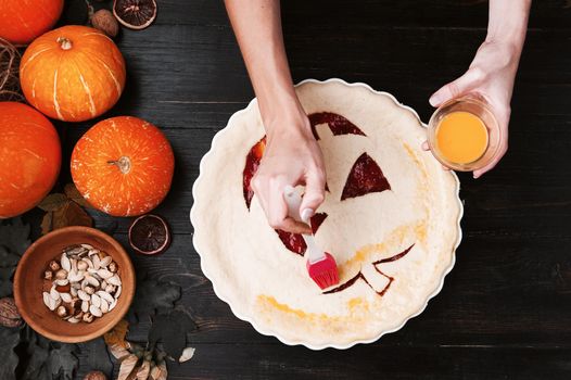 Chef cooks a pie for Halloween with a filling of pumpkin-strawberry jam and peaches