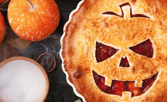 Delicious homemade pie for halloween with a filling of pumpkin-strawberry jam and peaches