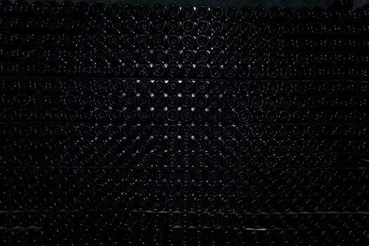 Rows bottoms of wine bottles dark color. Industrial texture or background.