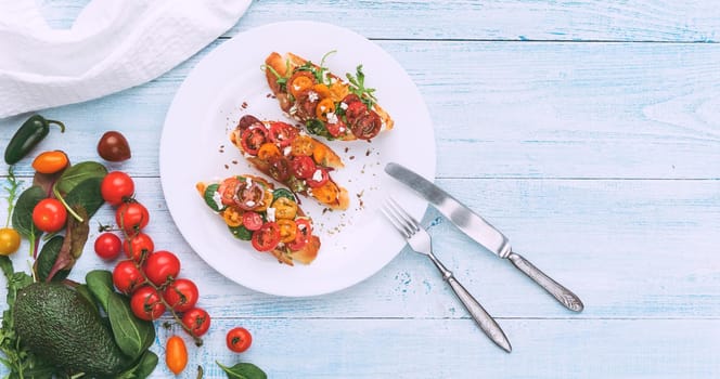 Bruschetta with cheese, basil, arugula and cherry tomatoes