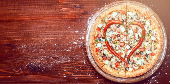 Valentine's Day pizza with peppers laid on top of a pizza