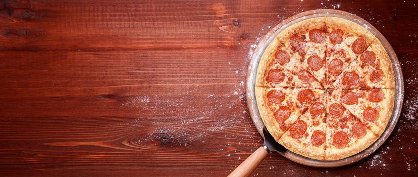 fresh american pizza on wooden table with space for text