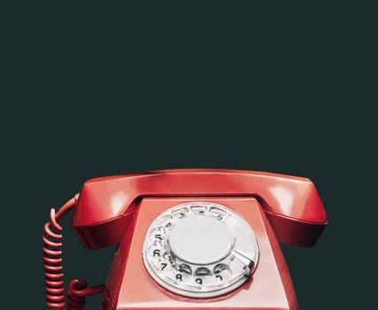 Vintage red telephone on black background.