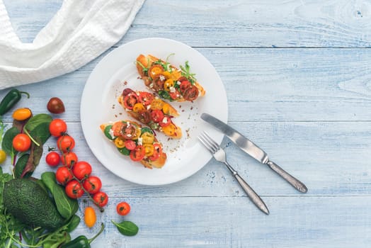 Bruschetta with cheese, basil, arugula and cherry tomatoes