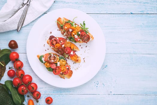 Bruschetta with cheese, basil, arugula and cherry tomatoes