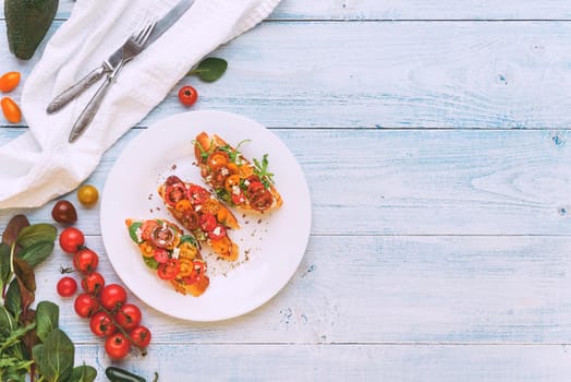 Bruschetta with cheese, basil, arugula and cherry tomatoes