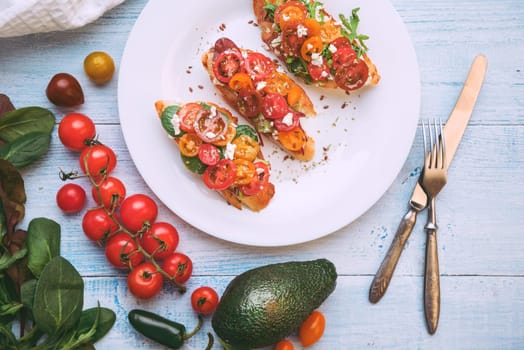 Bruschetta with cheese, basil, arugula and cherry tomatoes