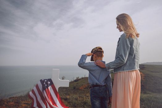 mother with son in the cemetery near the grave of the father of the American soldier who died in the ridge point defending the sovereignty and independence of the United States of America