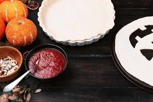 Chef cooks a pie for Halloween with a filling of pumpkin-strawberry jam and peaches