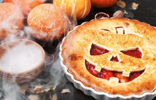 Delicious homemade pie for halloween with a filling of pumpkin-strawberry jam and peaches