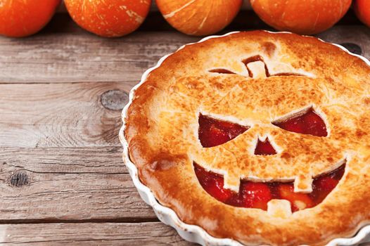 Delicious homemade pie for halloween with a filling of pumpkin-strawberry jam and peaches