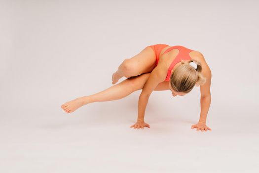 Beautiful female with dumbbells posing on a studio background