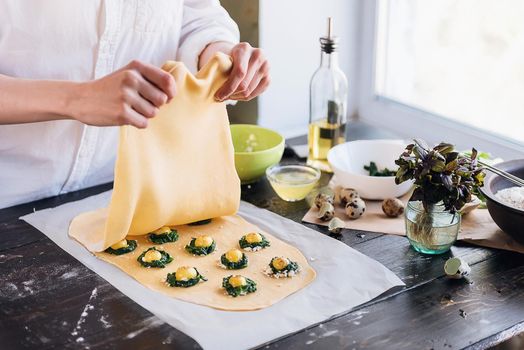 Step by step the chef prepares ravioli with ricotta cheese, yolks quail eggs and spinach with spices. The chef creates ravioli