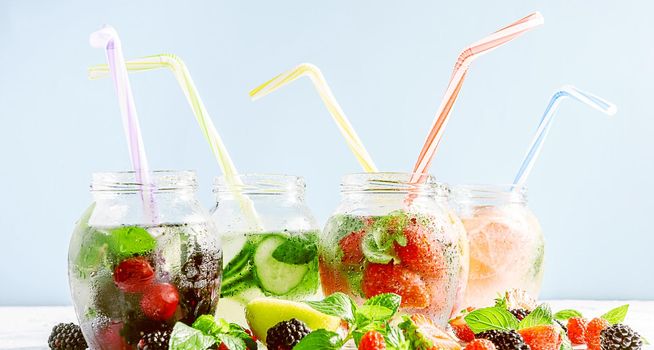 detox smoothies of fresh fruits and vegetables in glass jars with tubes. studio light, light background, space for text