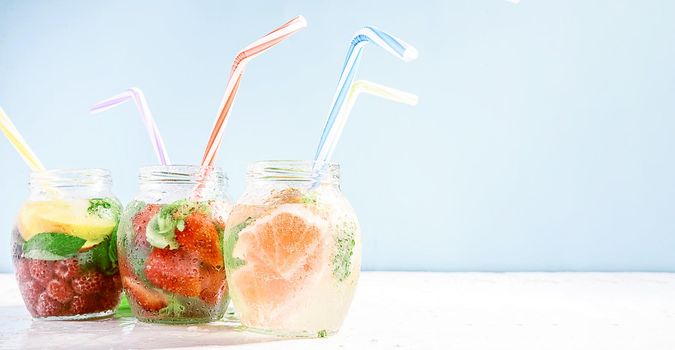 detox smoothies of fresh fruits and vegetables in glass jars with tubes. studio light, light background, space for text