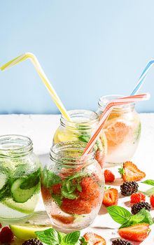 detox smoothies of fresh fruits and vegetables in glass jars with tubes. studio light, light background, space for text