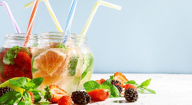 detox smoothies of fresh fruits and vegetables in glass jars with tubes. studio light, light background, space for text