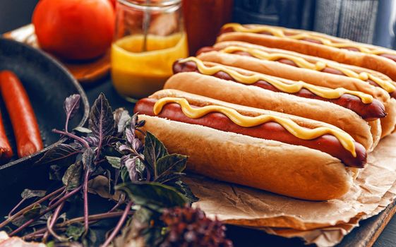 Barbecue Grilled Hot Dogs with  yellow American mustard, On a dark wooden background