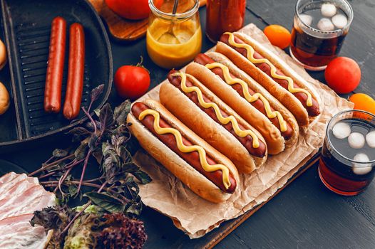 Barbecue Grilled Hot Dogs with  yellow American mustard, On a dark wooden background