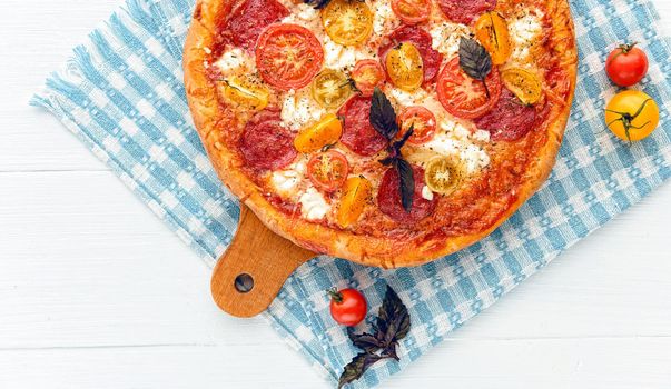 pepperoni italian pizza with salami and cheese on rustic wooden white background