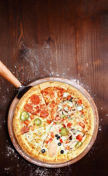 mix of eight different pizzas on a wooden background. menu concept of choice and diversity