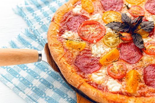 pepperoni italian pizza with salami and cheese on rustic wooden white background