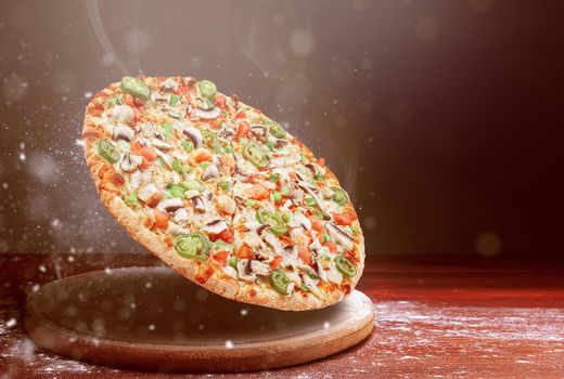 classic pizza on a dark wooden table background and a scattering of flour. pizza restaurant menu concept