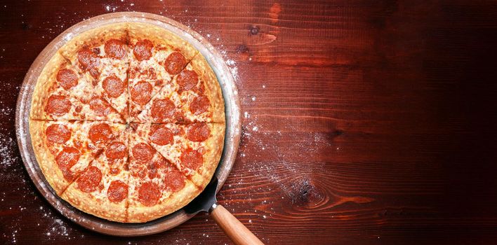 fresh american pizza on wooden table with space for text