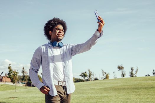 Young afro man taking selfie in a park