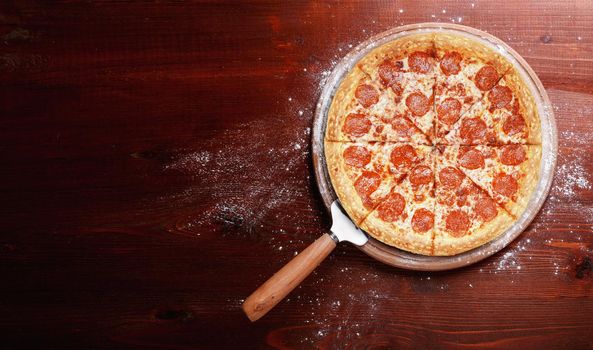 fresh american pizza on wooden table with space for text