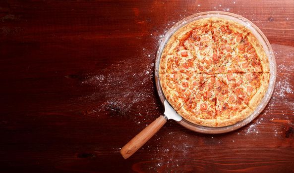 fresh american pizza on wooden table with space for text