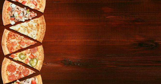 mix of eight different pizzas on a wooden background. menu concept of choice and diversity