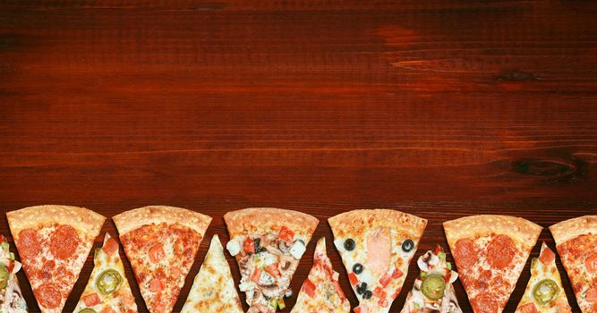 mix of eight different pizzas on a wooden background. menu concept of choice and diversity