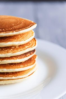 fresh classic pancake stacked in stack on gray background with place for text